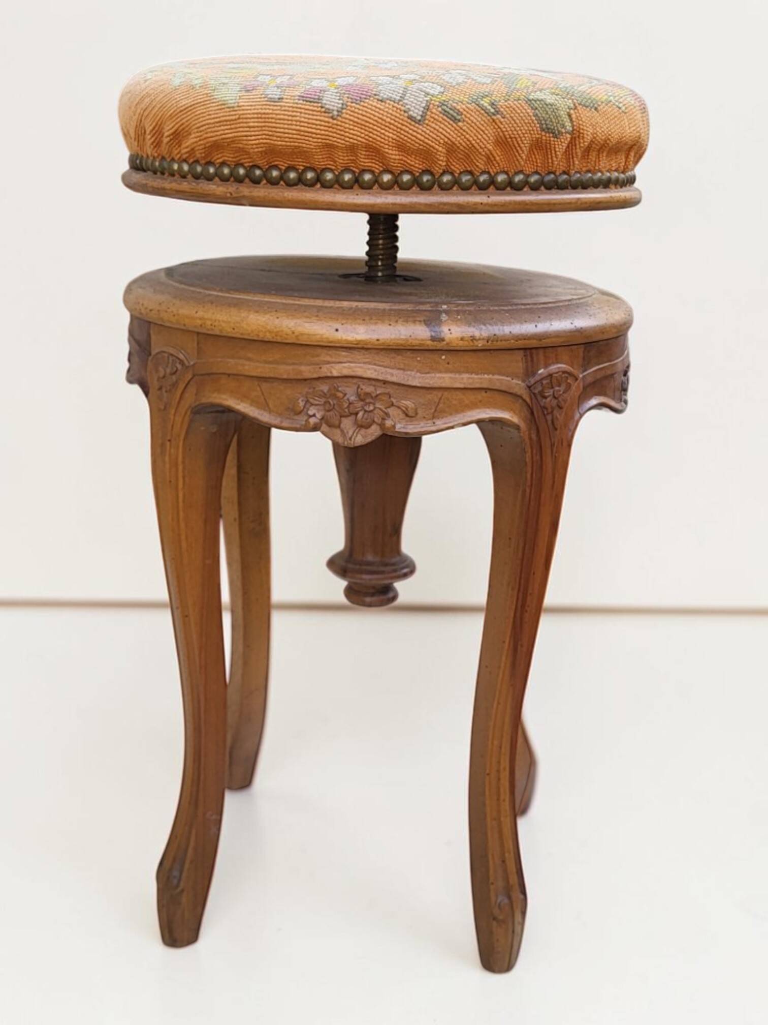 Swivel piano stool with screw, Louis XV style, in walnut.