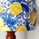 Turned wooden lamp with a lampshade featuring lemon tiles.