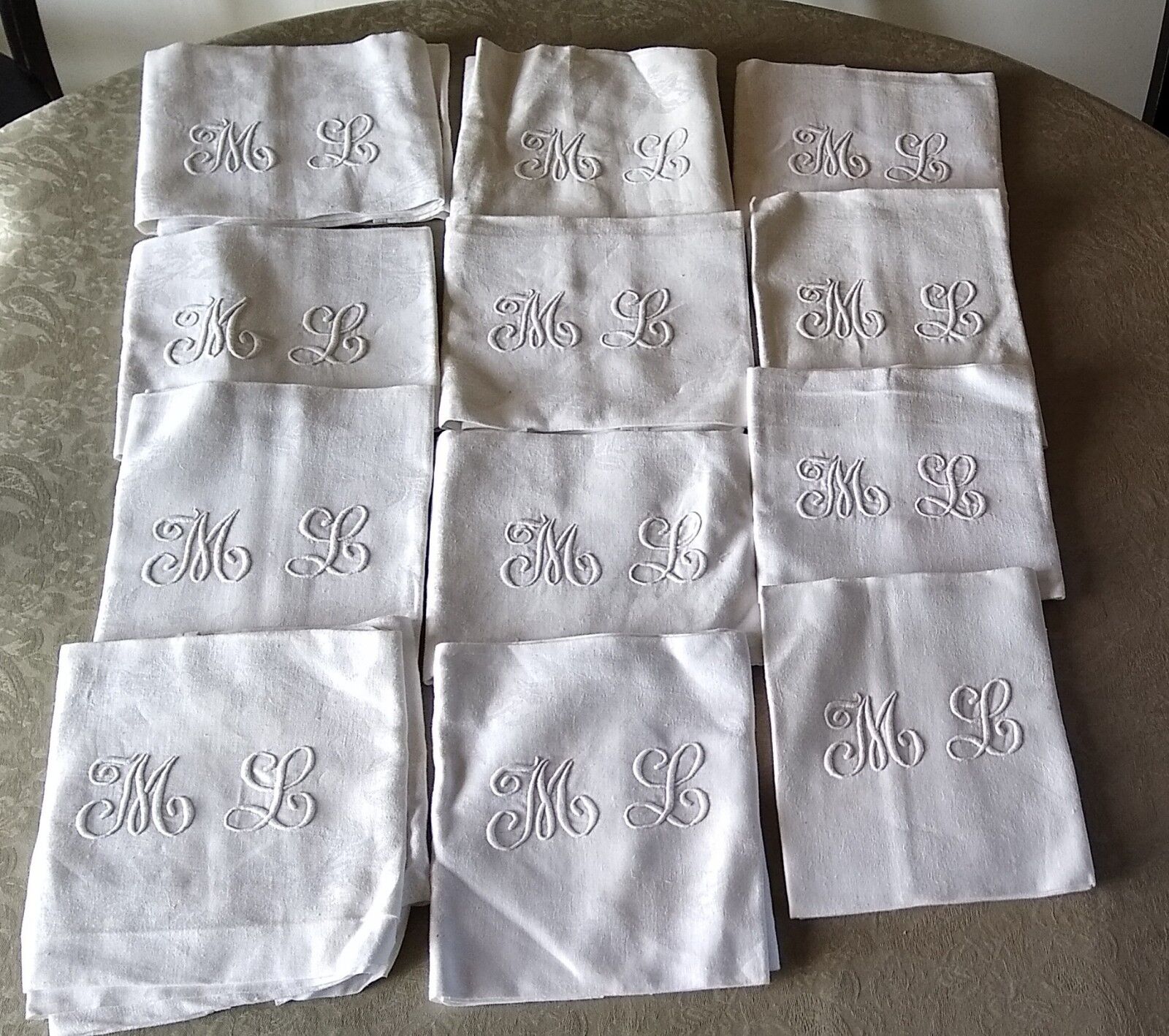 12 large antique damask towels with floral decoration and embroidered with the ML monogram
