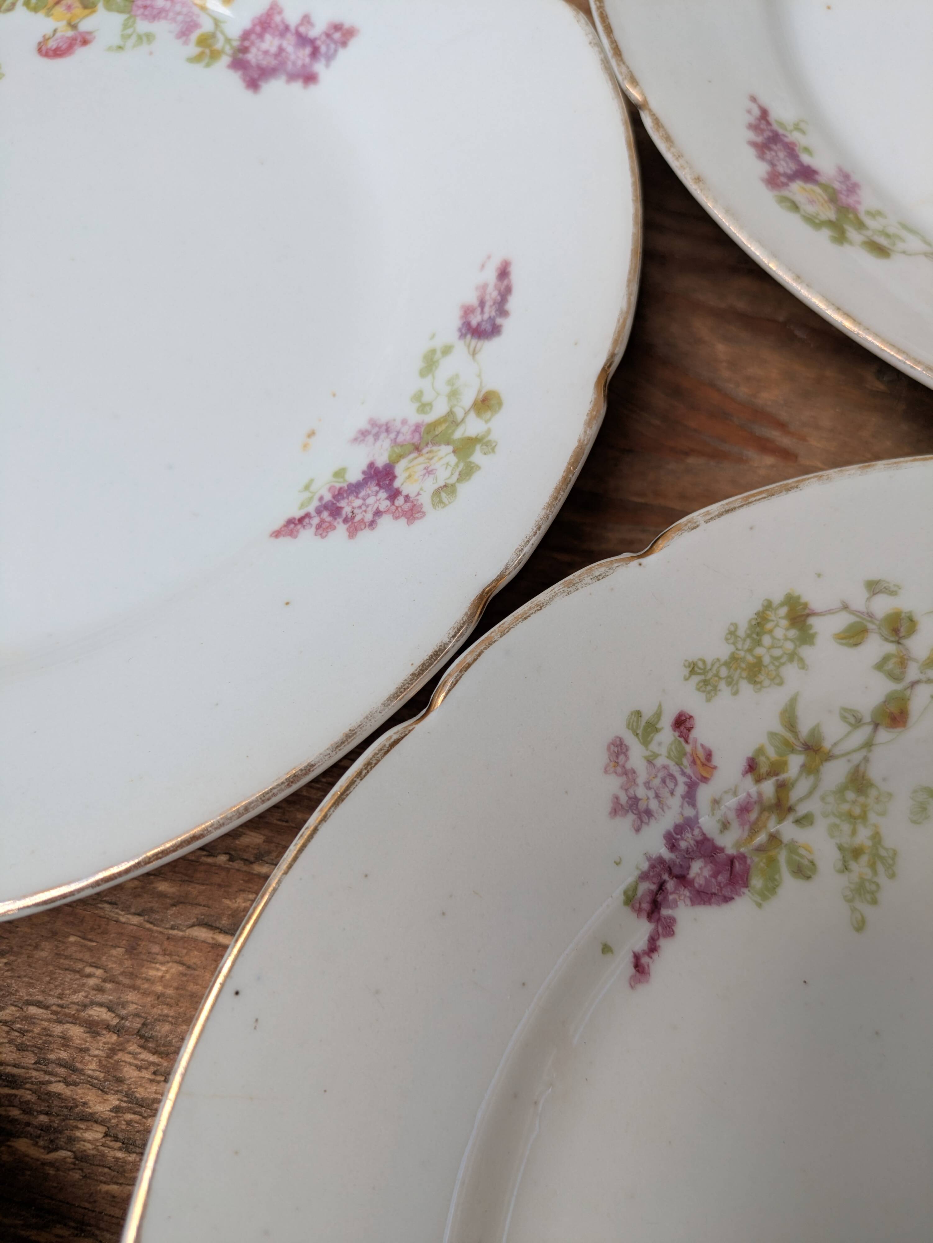 7 dessert plates in porcelain with a violet lilac design and a gold rim.
