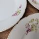 7 dessert plates in porcelain with a violet lilac design and a gold rim.
