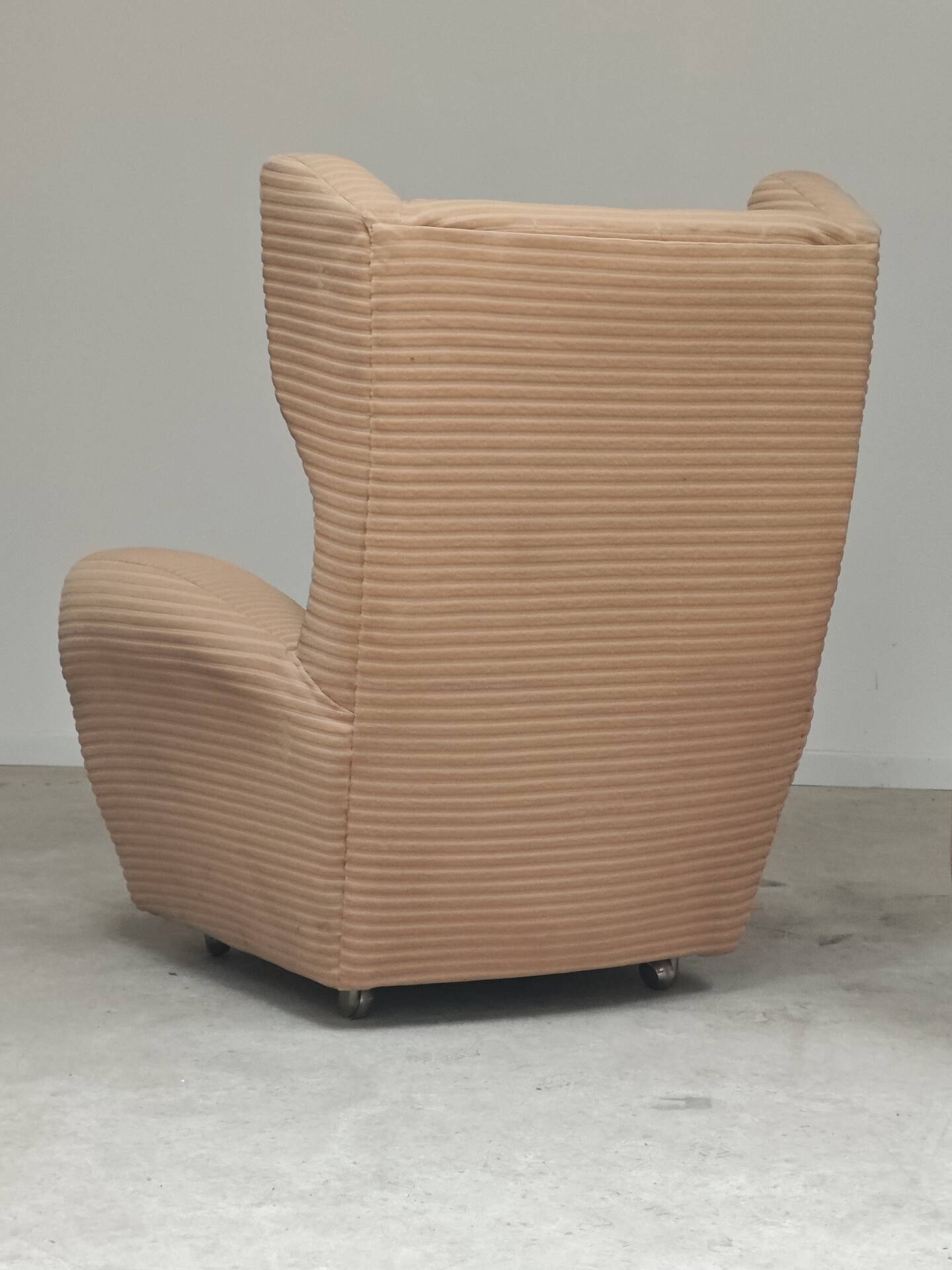 Beige wingback armchair and TVAR footrest, former Czechoslovakia.
