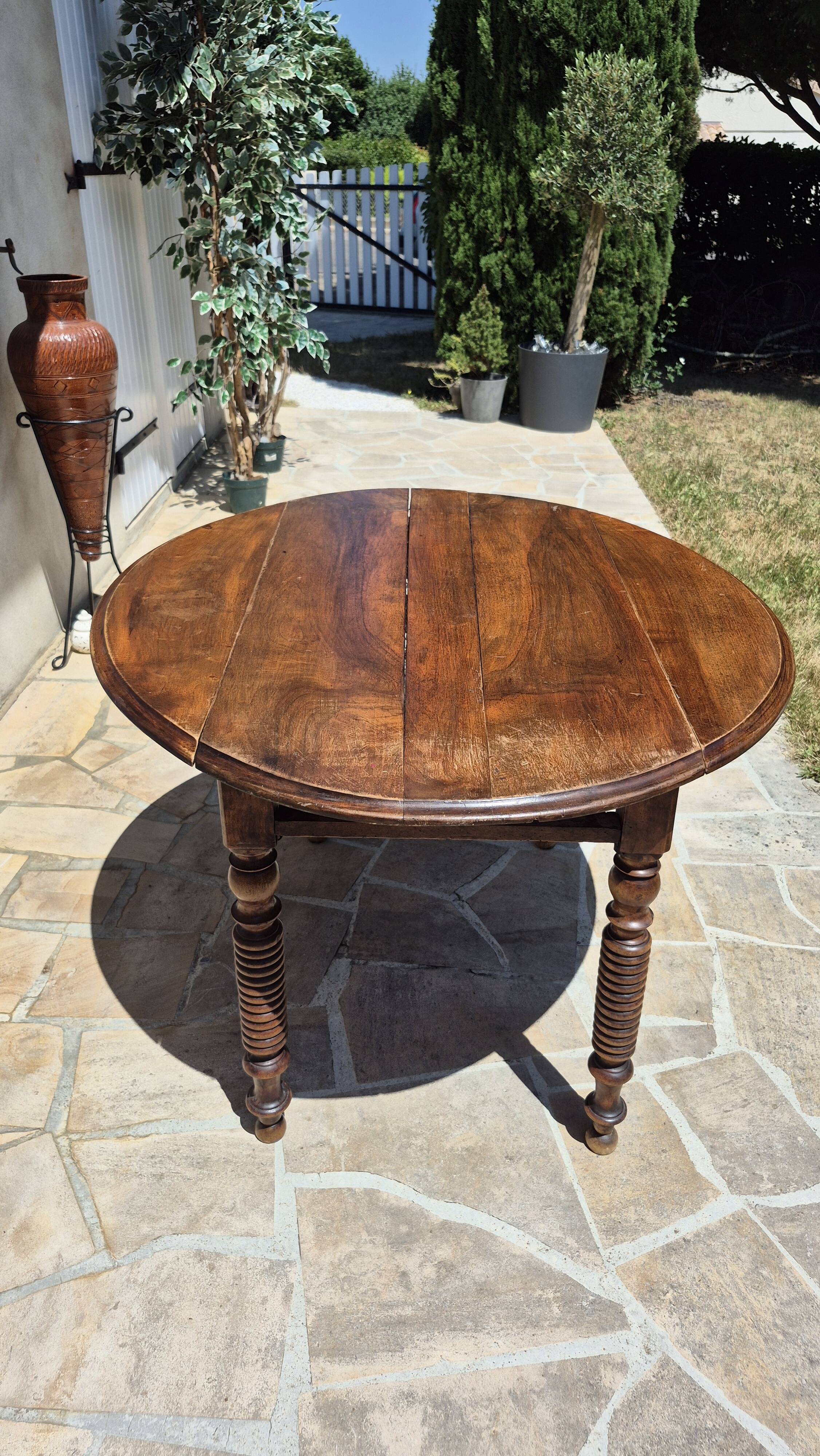 Round dining table with a drop-leaf top in solid walnut, late 19th century.