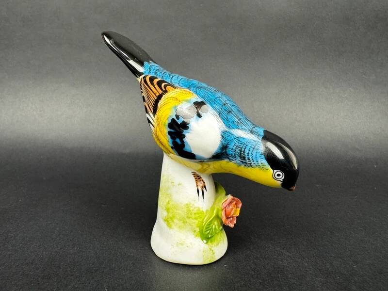 Porcelain figurine of a polychrome bird on a vintage floral base