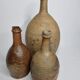 Set of three old enamelled terracotta bottles, 33 cm