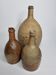 Set of three old enamelled terracotta bottles, 33 cm