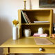 Desk table from the late 19th century, painted mustard, with turned stretcher.