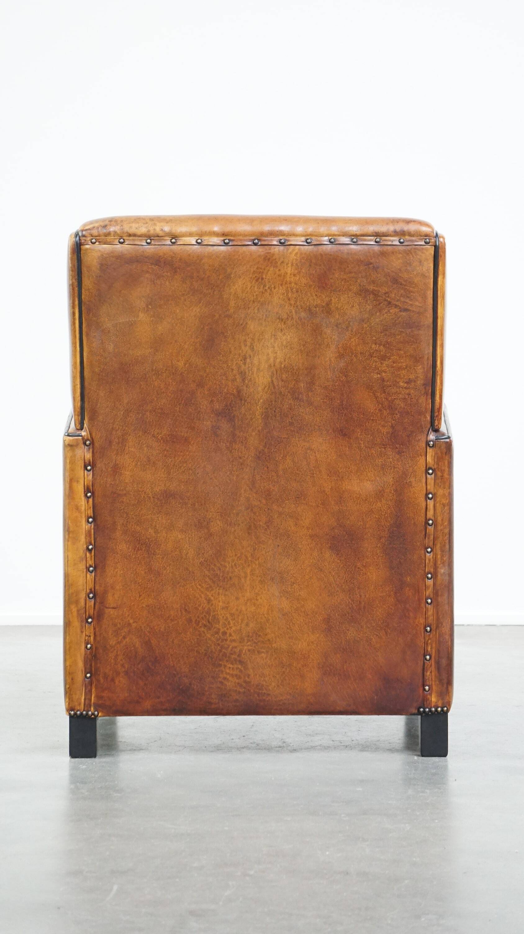 Art Deco design sheepskin leather armchair with a stunning patina