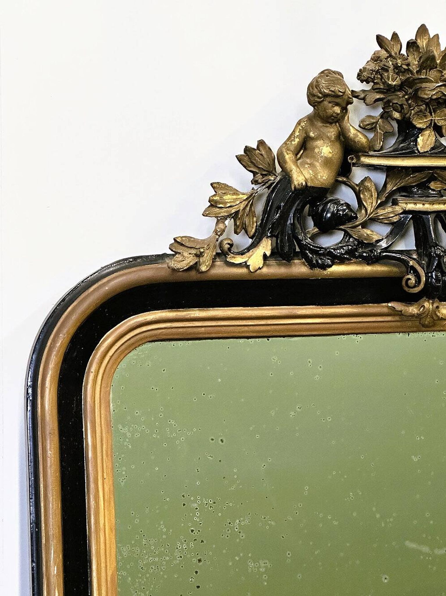 Antique 1800s black and gold mirror with cupid, France 1800s.
