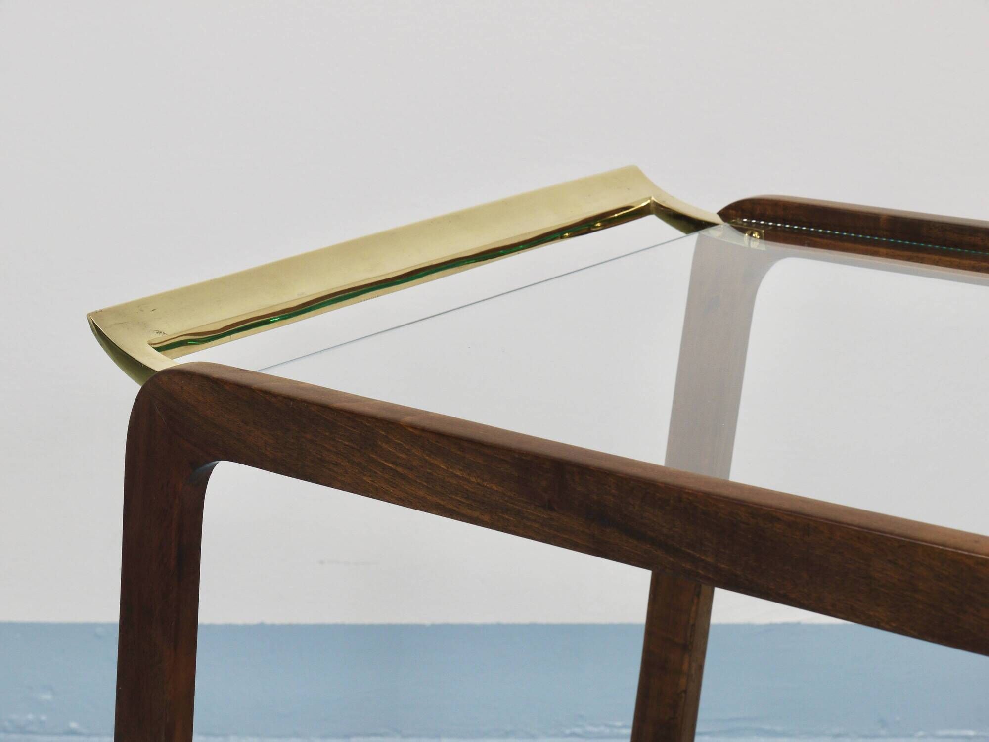 May include: A mid-century modern bar cart with a dark wood frame and two c