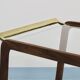 May include: A mid-century modern bar cart with a dark wood frame and two c