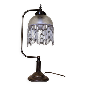 Retro brass lamp with a glass shade and bead fringes.