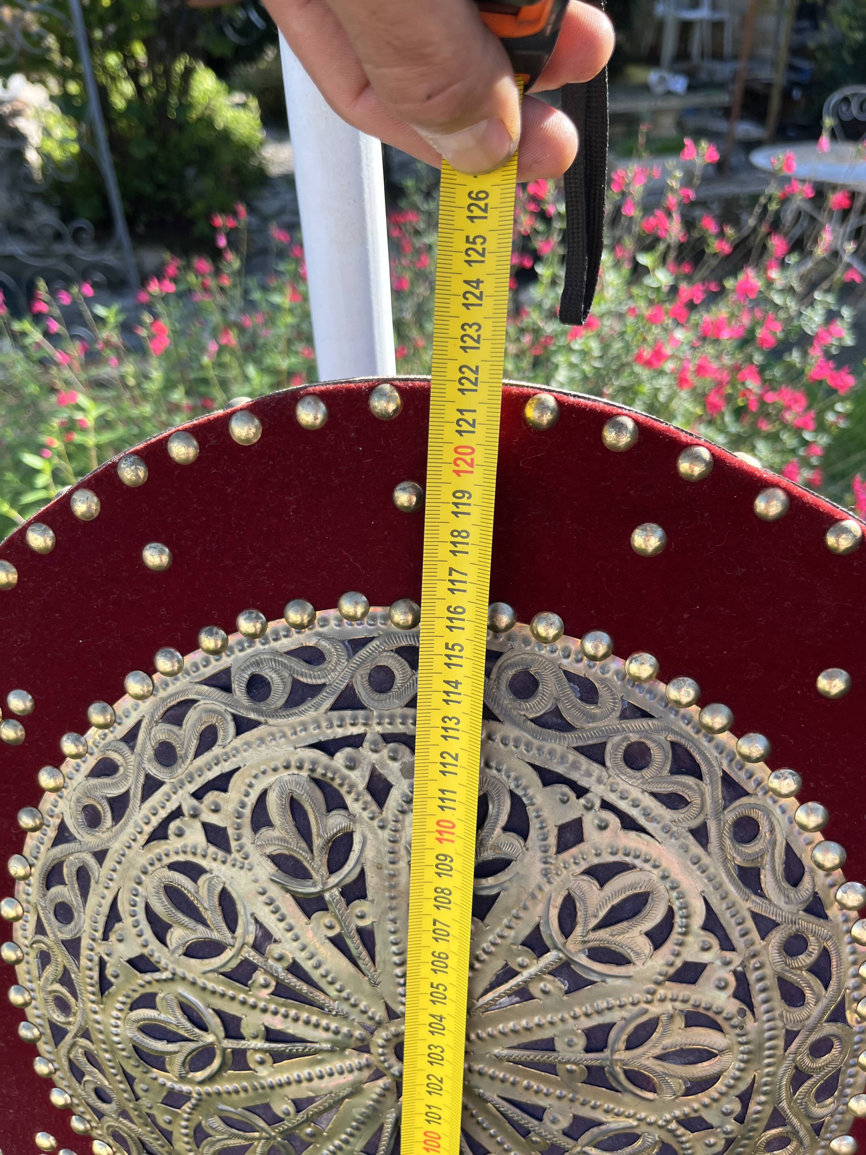 Large oriental mirror with embossed brass decoration on a red velvet background