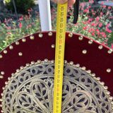 Large oriental mirror with embossed brass decoration on a red velvet background