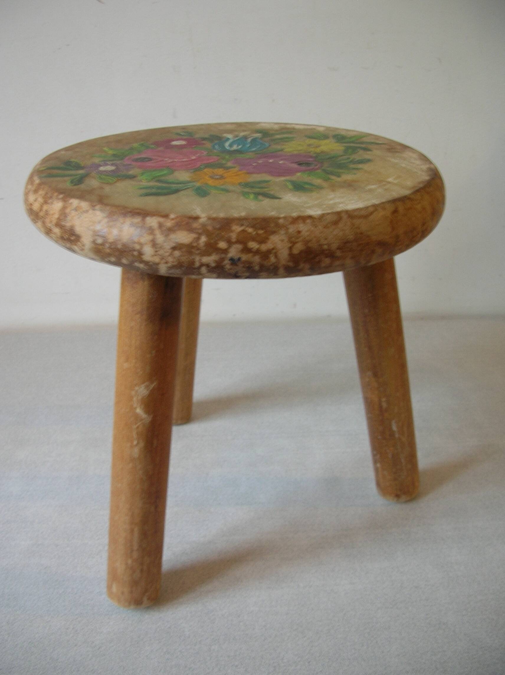 Old tripod stool with 3 wooden legs, painted floral decoration, flower bouquet