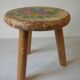 Old tripod stool with 3 wooden legs, painted floral decoration, flower bouquet