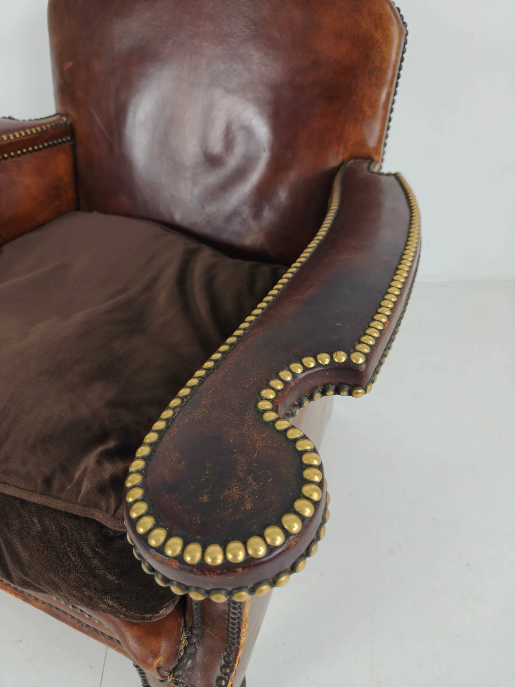 Antique leather club chair with stud detailing