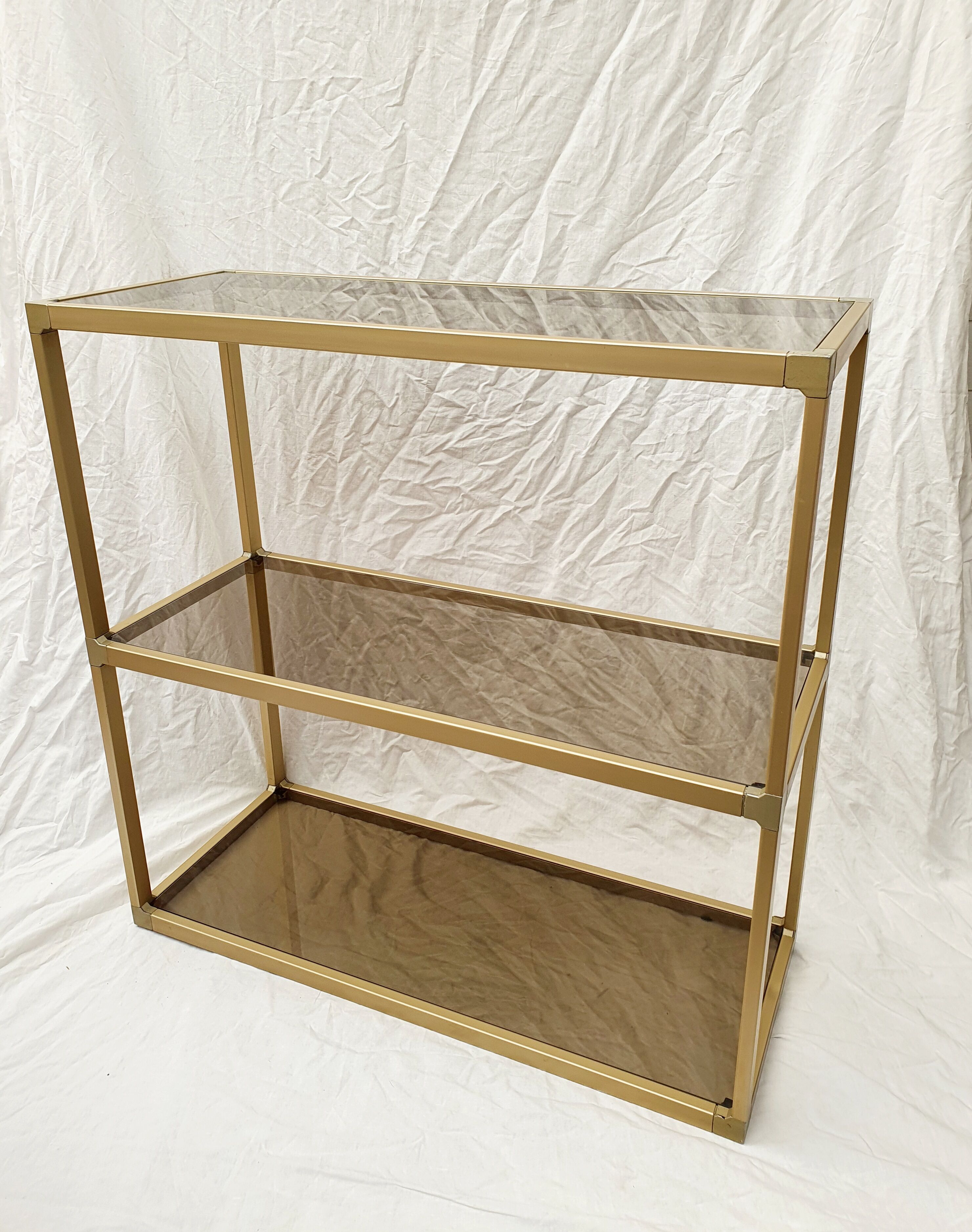 Golden metal shelf and smoked glass