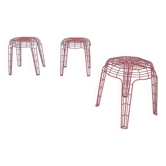 Set of three red metal wire stools