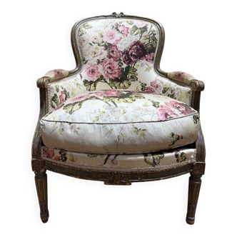 Reupholstered bergère with floral fabric in Louis XVI style.