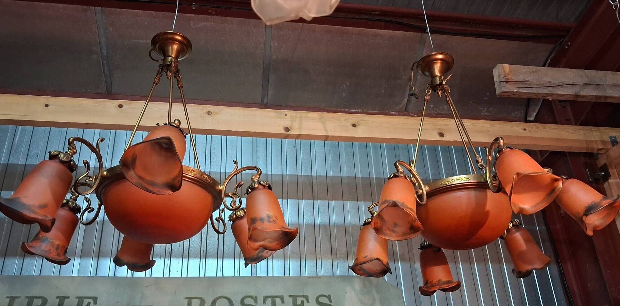 Pair of Art Nouveau style chandeliers in bronze and orange glass paste.