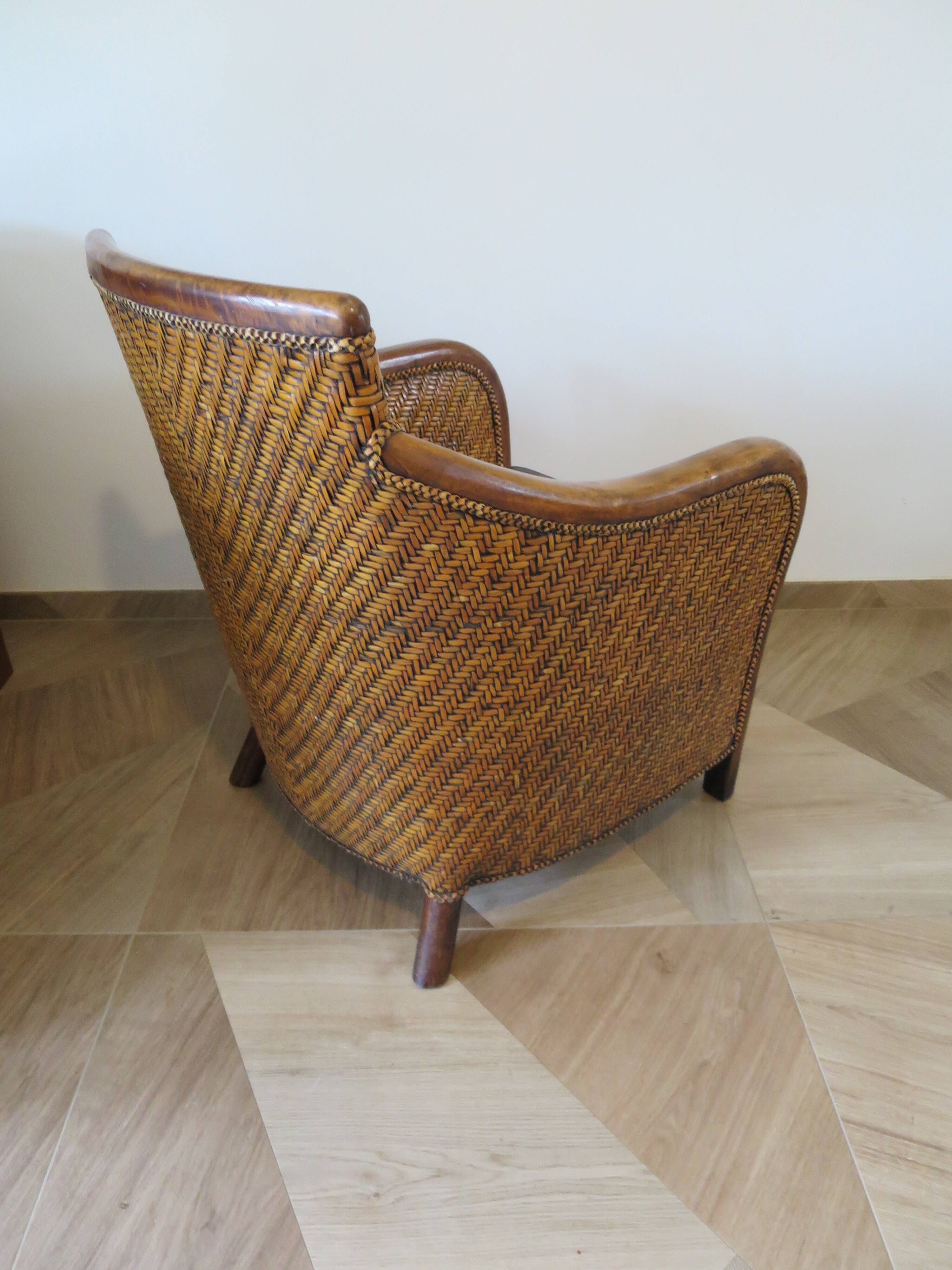 Colonial style armchair in woven rattan and exotic wood