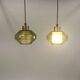 Hanging lamp with an outer shade of olive green glass and an inner shade of clear, crystal glass.