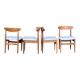 Un ensemble de chaises GPlan en teck avec un tissu laineux blanc