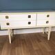 White retro wooden commode in Mid-Century style, tapered legs and gold handles (1960s)