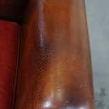 Sheepskin leather wingback chair with a red corduroy seat cushion