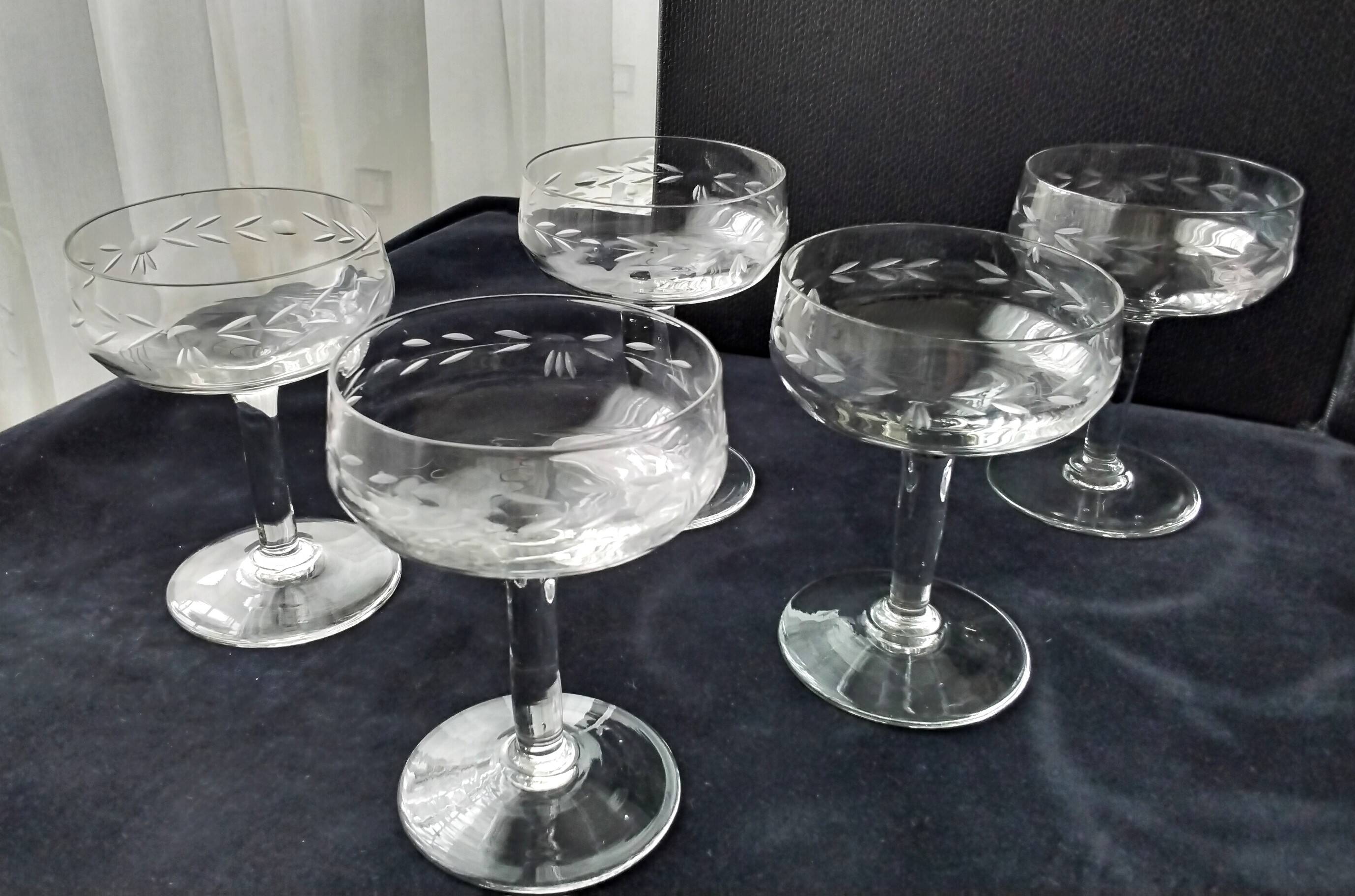 8 vintage glass champagne coupes with an engraved frieze decoration.