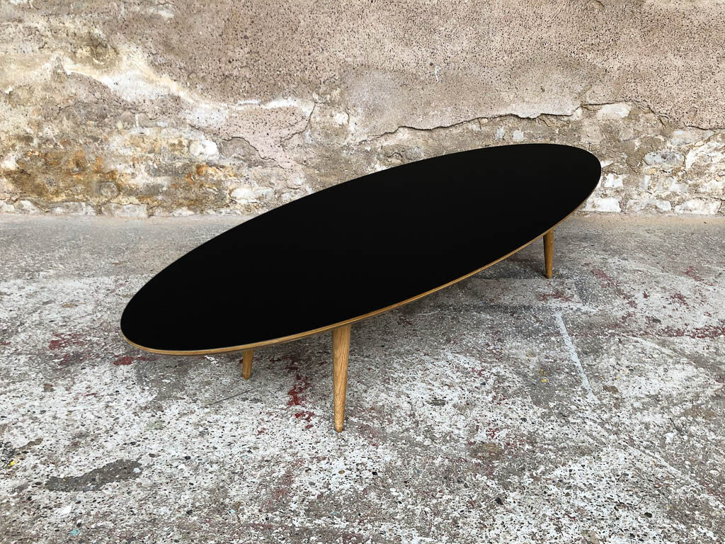 Oval coffee table with a black tray and oak-turned feet