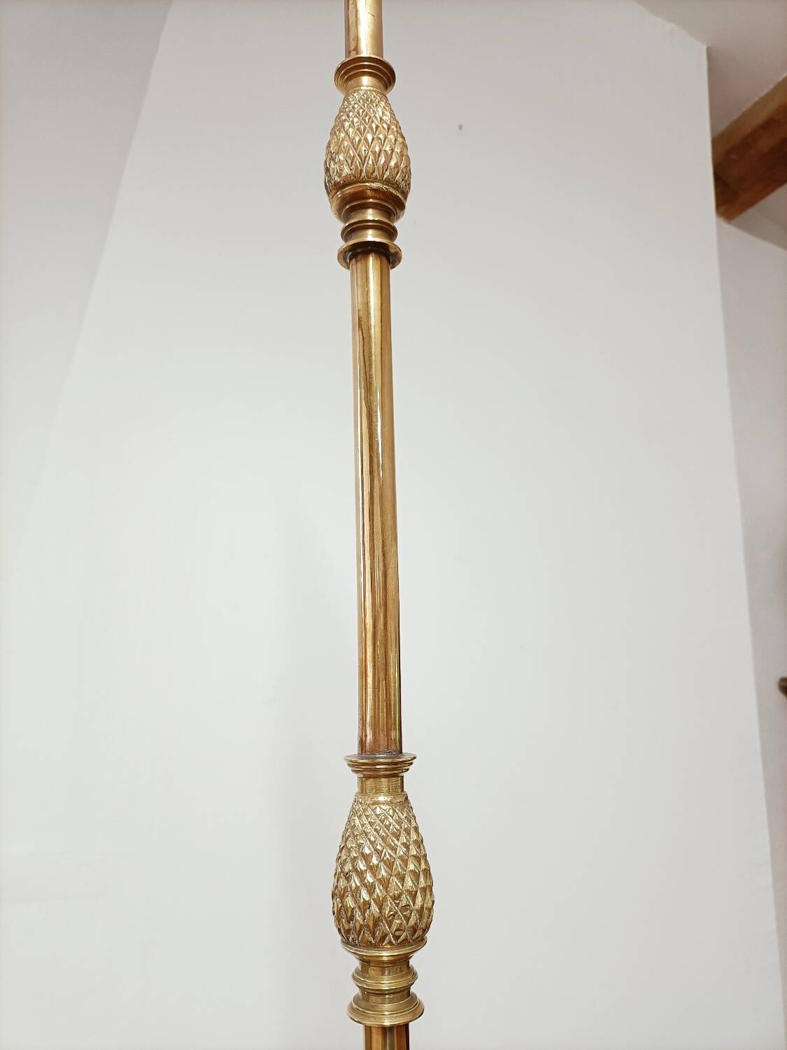Bronze floor lamp with pine cone decoration.