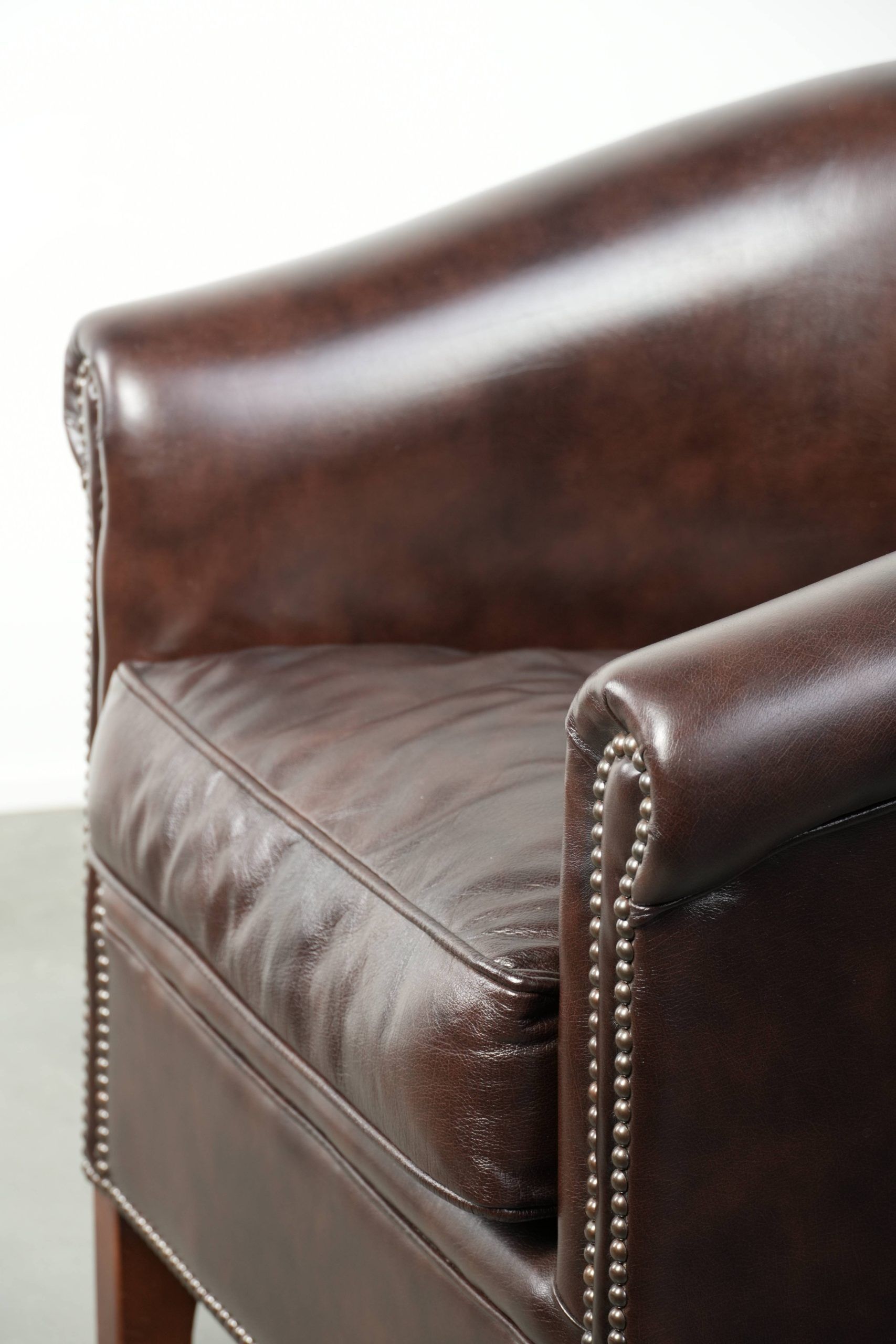Dark cow leather club armchair in good condition with an English design