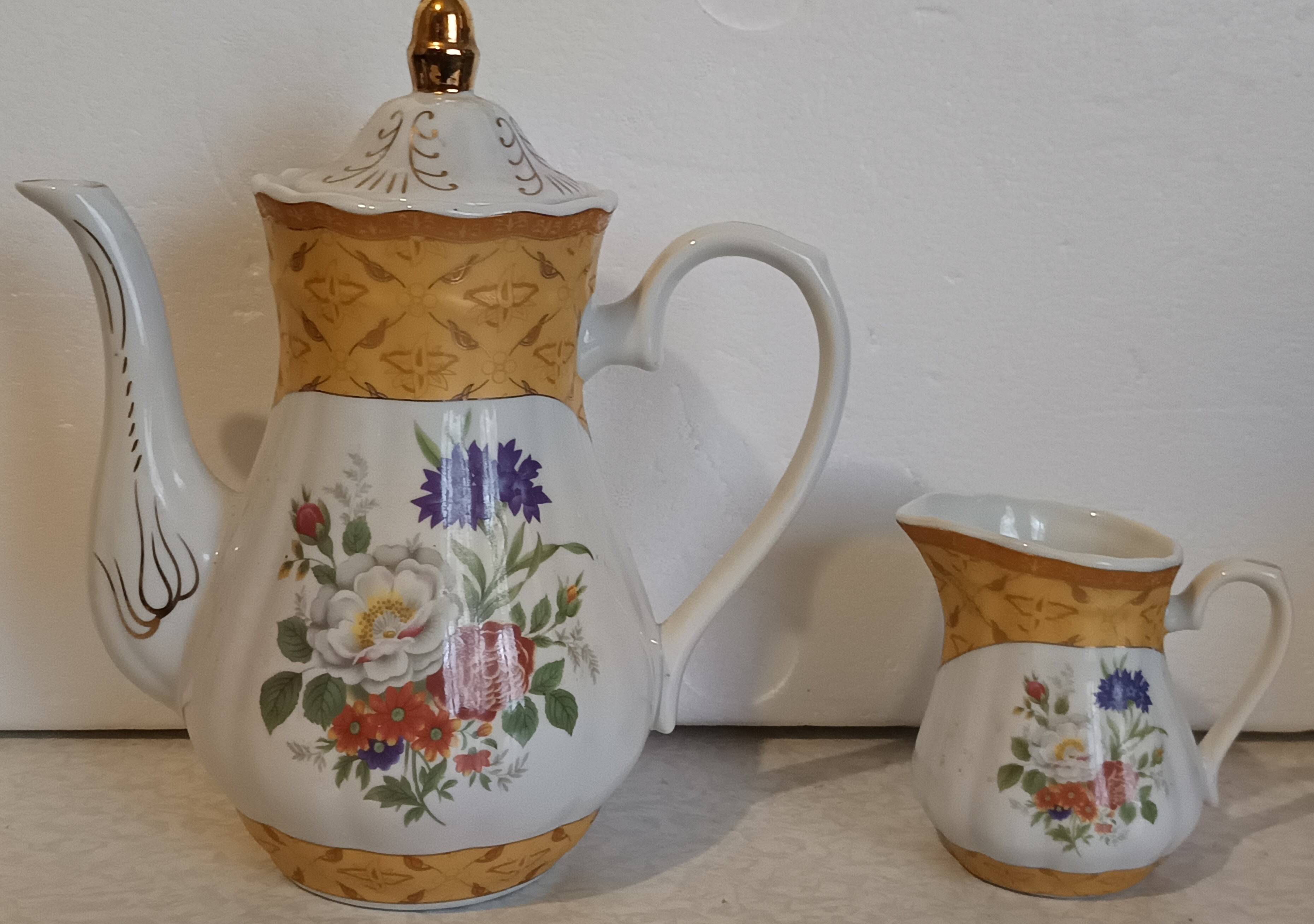 Golden porcelain teapot and coffee pot set with floral design and matching milk jug.