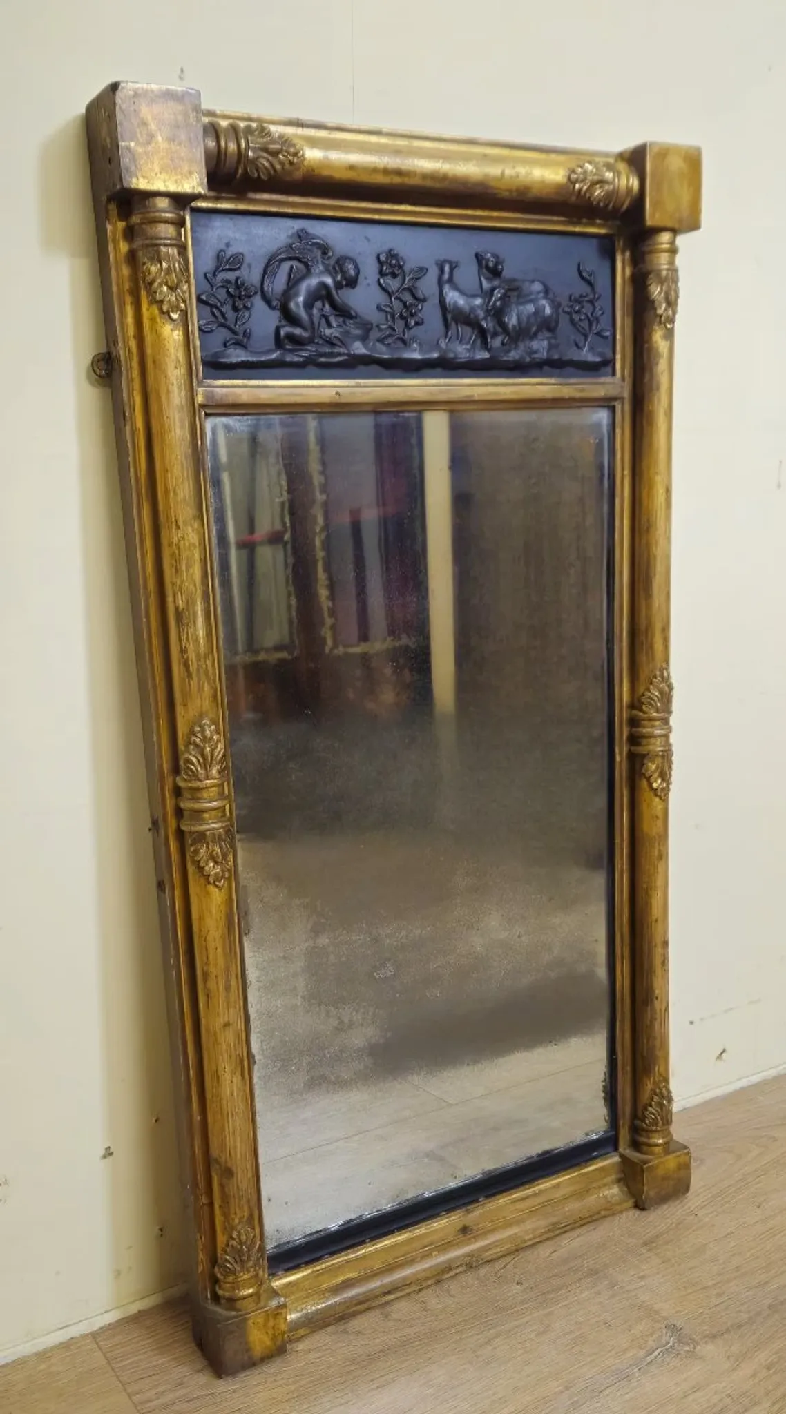 Large antique gilded wooden mirror with terracotta relief from the Empire period.