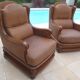 Pair of aged leather armchairs with seat and firm backrest with cherry wood frame