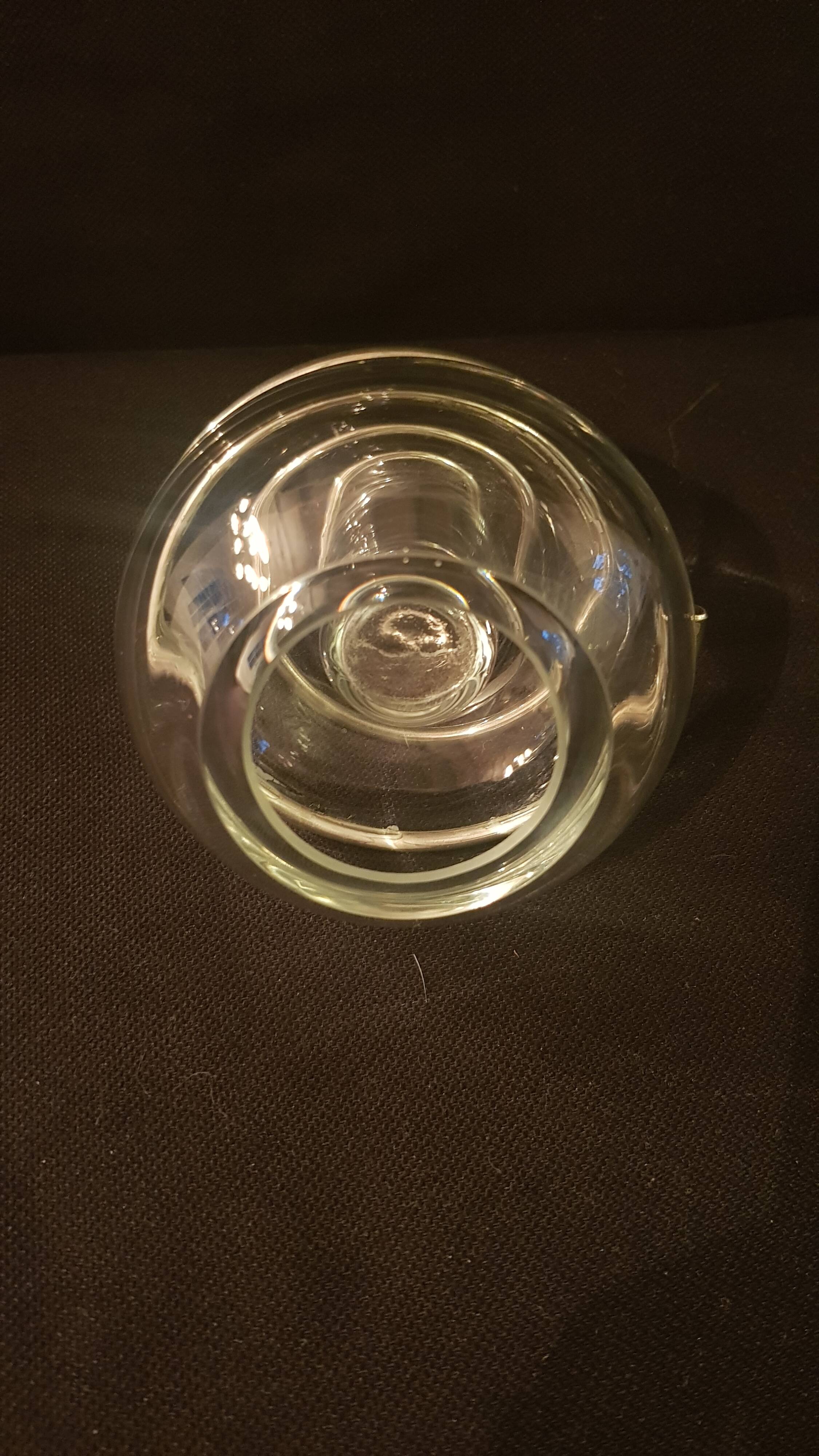 Round glass candle holder with silver-plated metal spiral.