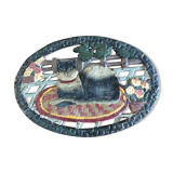 Dessous de plat en fonte avec un motif de chat sur son tapis