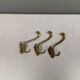 Three old and beautiful brass hooks with decorative motifs