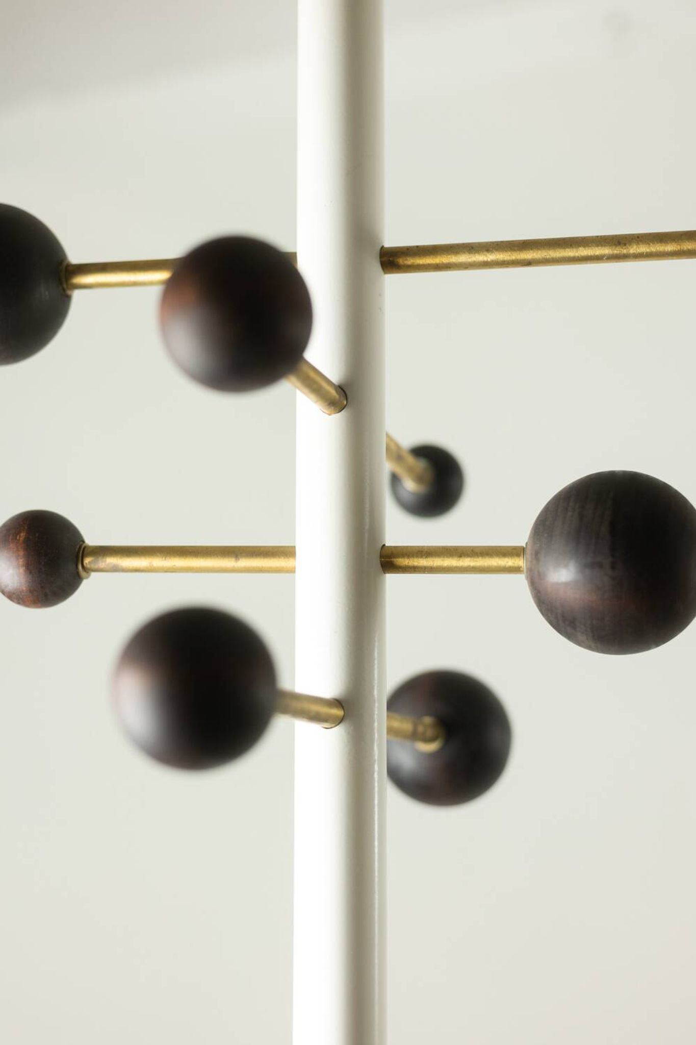 Coat rack from floor to ceiling in lacquered metal and brass. Contemporary.