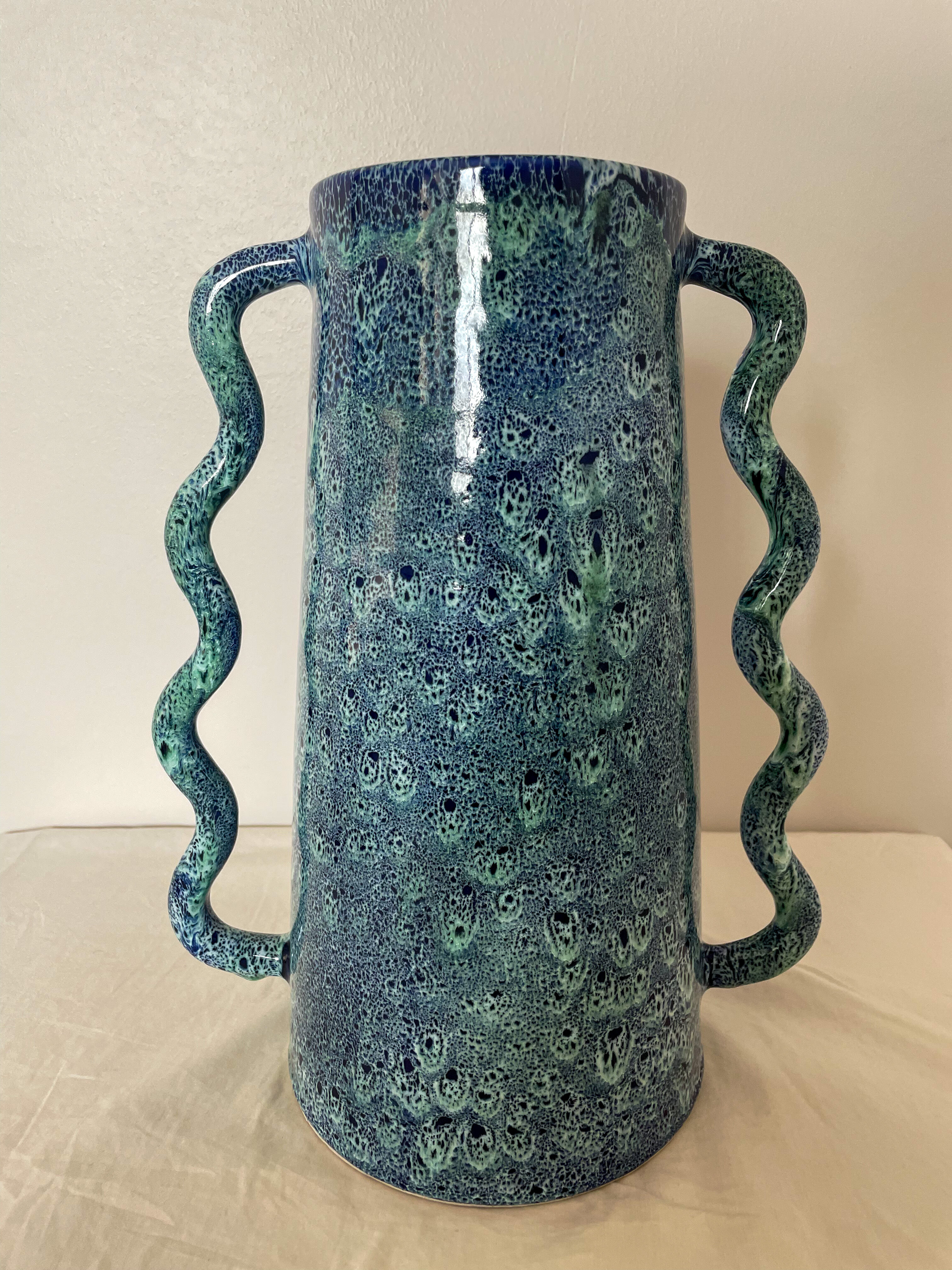 Blue-green ceramic vase with abstract wavy handles