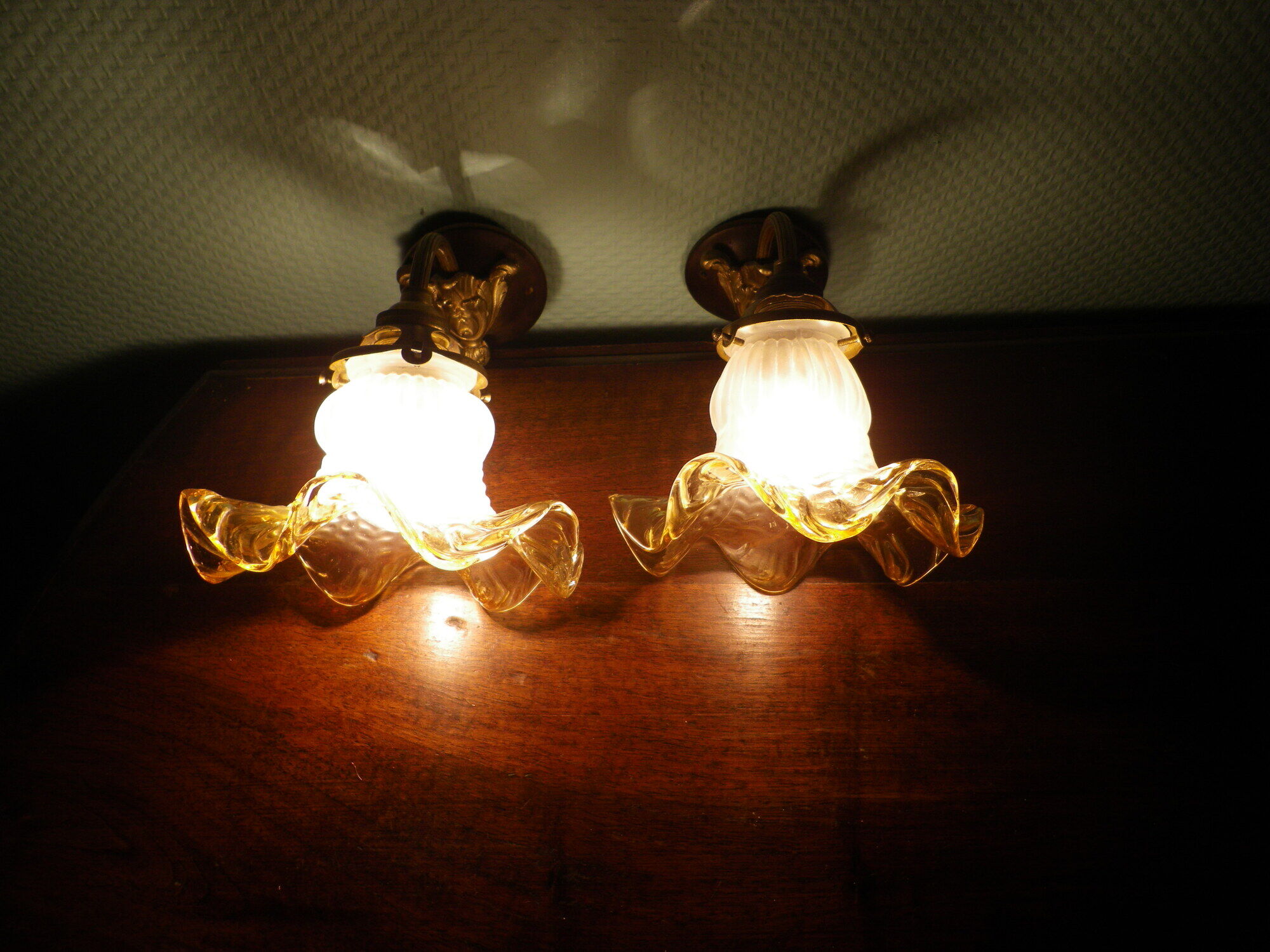 Wall lamps, opaque corolla and iridescent ochre lampshade, brass and wood support