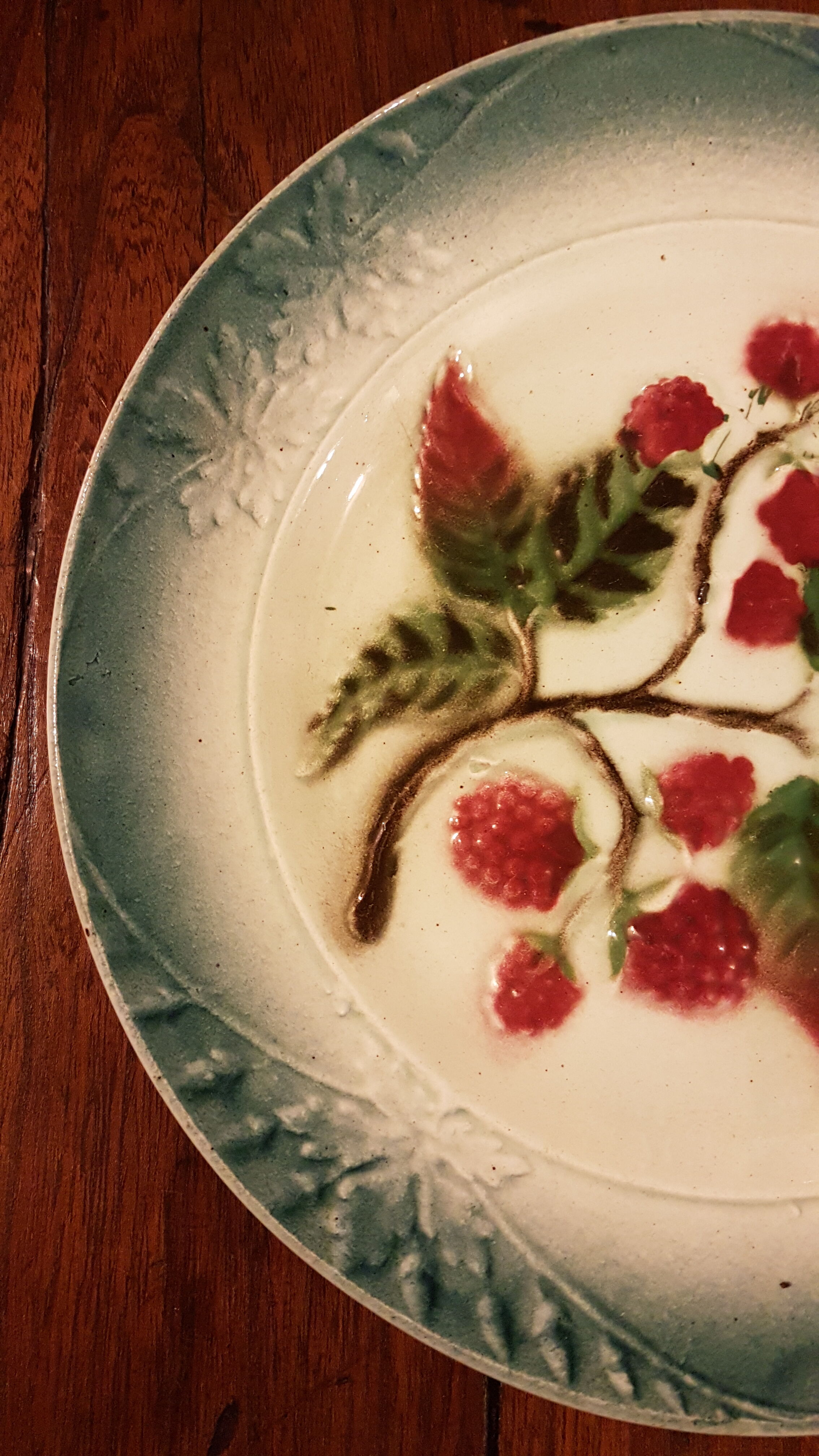 Old plate with decoration of raspberries
