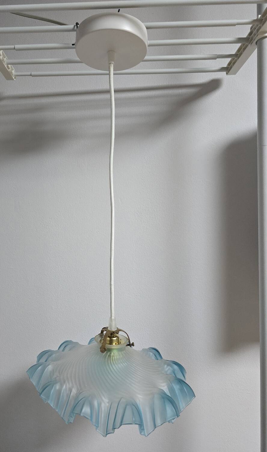 Suspension lampshade with scalloped edges in blue and its interior decoration.