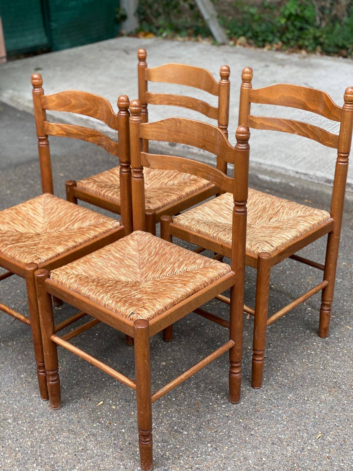 4 solid wood kitchen chairs with straw seats in a country farmhouse style.