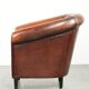 Sheepskin club armchair with deep warm colours and black piping