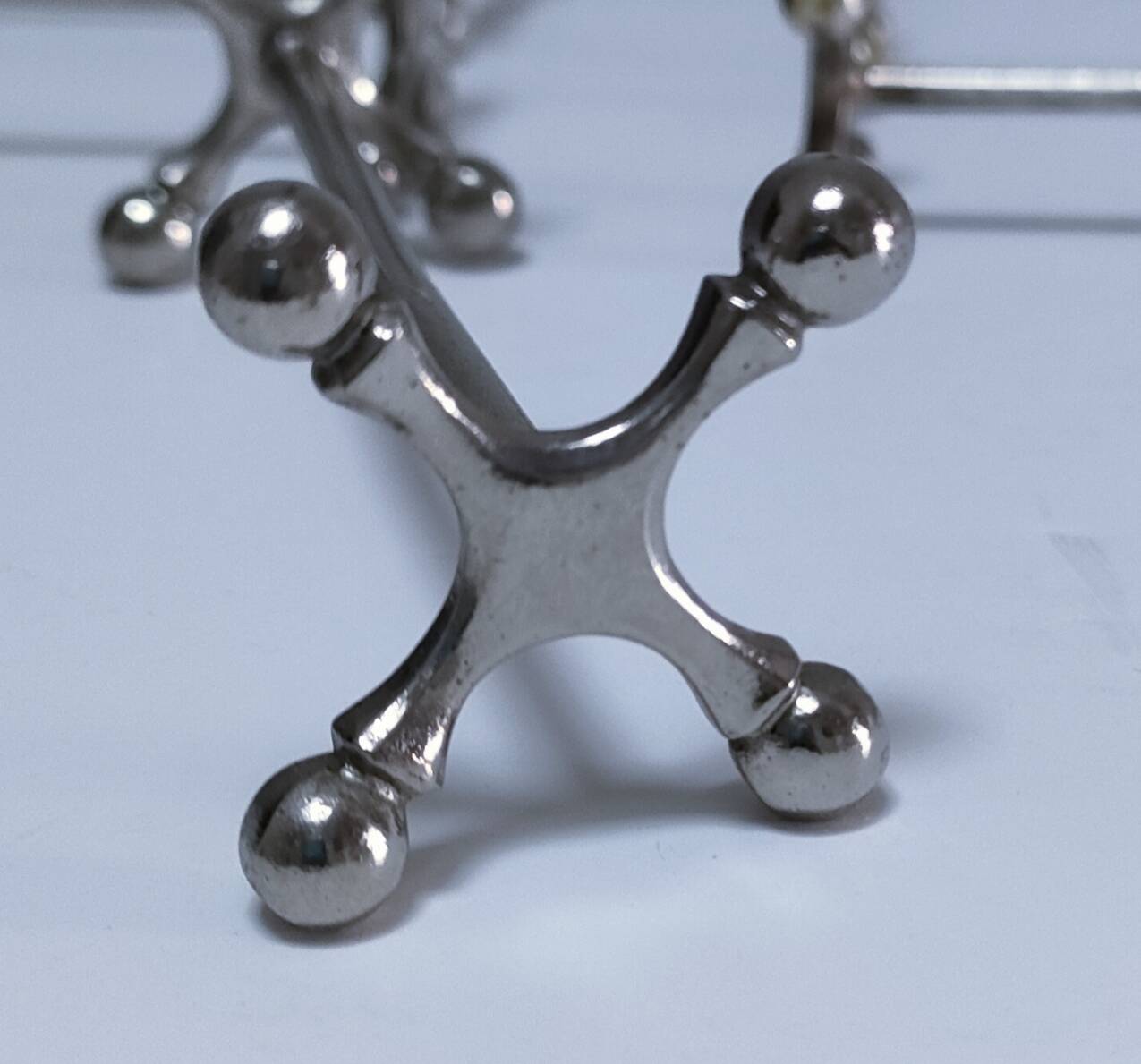 Eleven 70s design metal "crosshair" knife holders