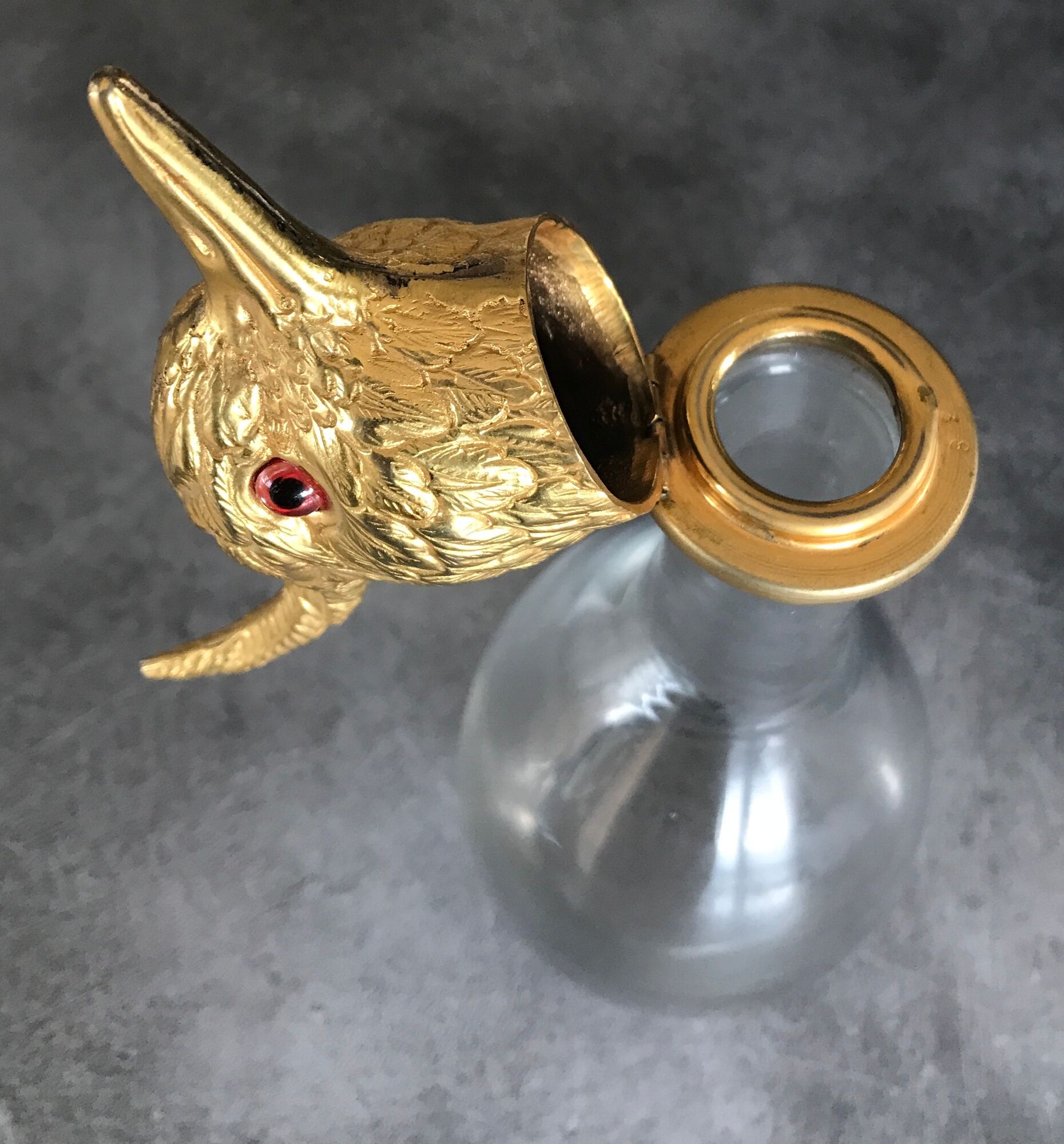 Glass bottle type carafe with gold metal bird head stopper