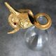 Glass bottle type carafe with gold metal bird head stopper